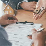 Negociação imobiliária com entrega de chaves, contrato e miniatura de casa