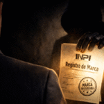Executivo de terno analisa certificado de registro de marca do INPI em ambiente corporativo reservado