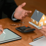 Time de advogados do escritório Martins & Thomé Pacheco, Reunião sobre negócio imobiliário com miniatura de casa e documentos